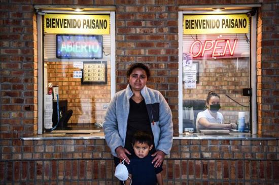 2021年3月14日，一位来自中美洲的移民和她的儿子在得克萨斯州布朗斯维尔市和墨西哥塔毛利帕斯市马塔莫罗斯市之间的盖特国际大桥等车。